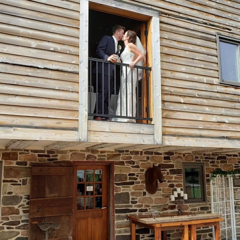 Couple kissing on a wooden balcony above a stone building